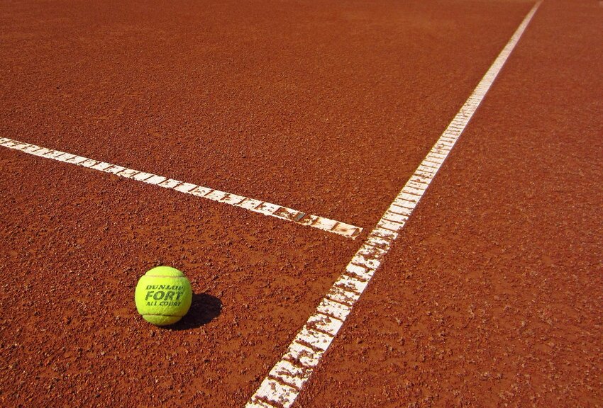 Powiększ: Grafika przedstawia piłkę do tenisa ziemnego leżącą na boisku.