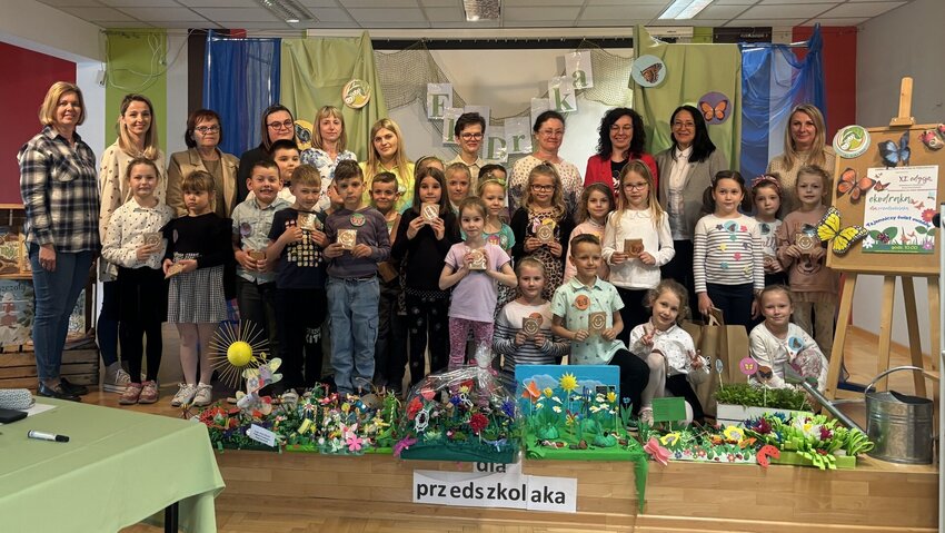 Powiększ: Grupa przedszkolaków i osób dorosłych stojąca na scenie do fotografii