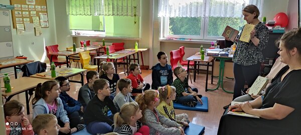 Dzieci podczas czytania książki przez panie bibliotekarki w SP Pielgrzymowice