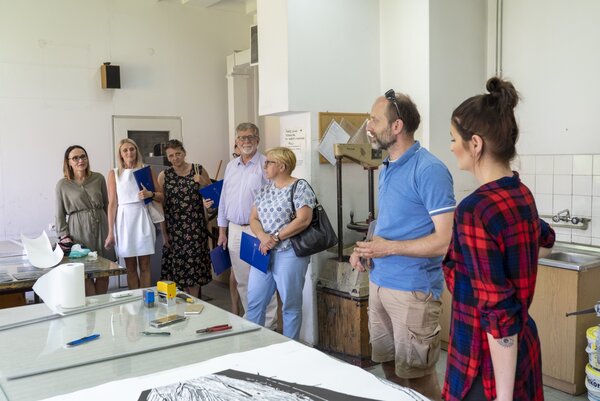 Na zdjęciu stoją osoby zwiedzające Wydział Sztuki i Nauk o Edukacji