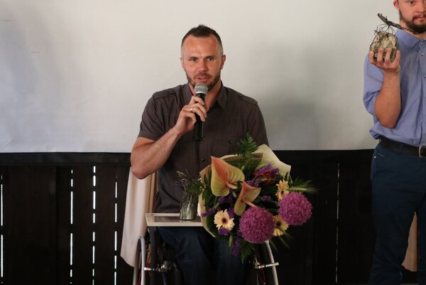 Na zdjęciu Szymon Klimz przemawiający do mikrofonu