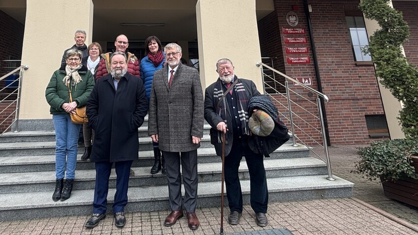 Powiększ: Grupa osób stojąca na schodach przed urzędem.