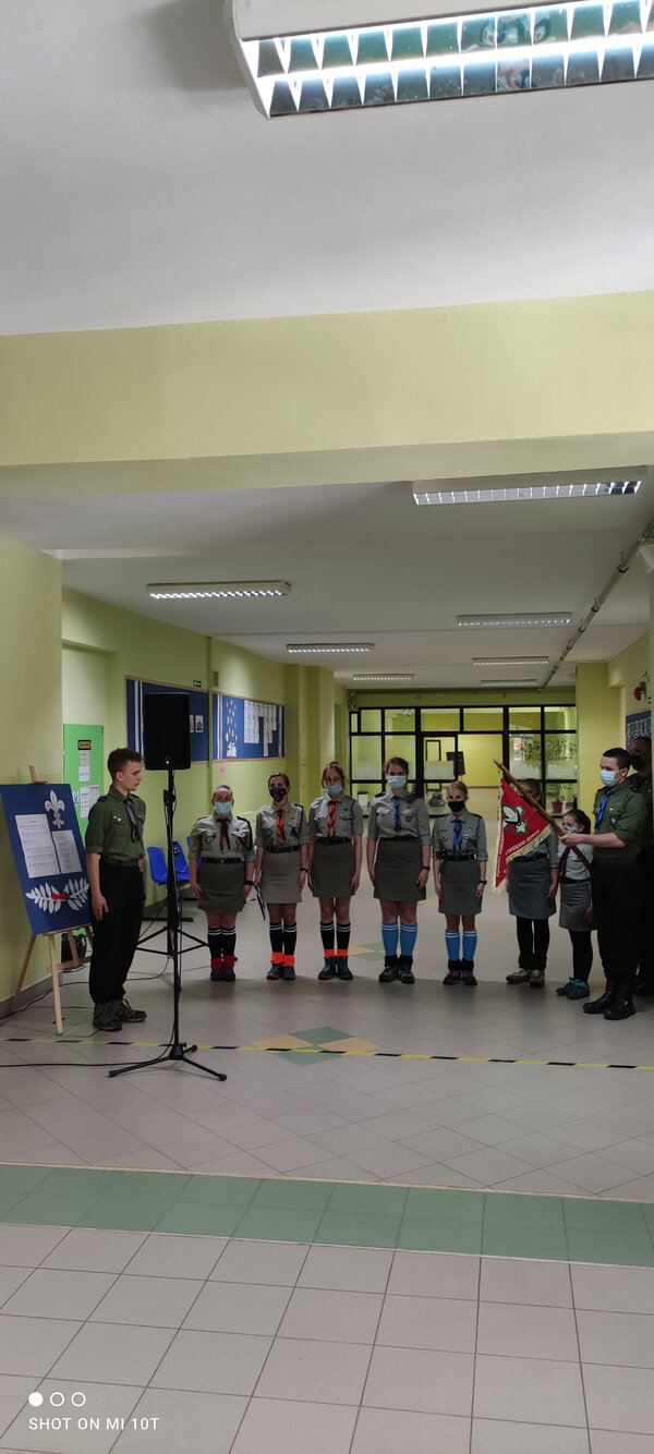 Harcerze stojący na baczność podczas uroczystości.